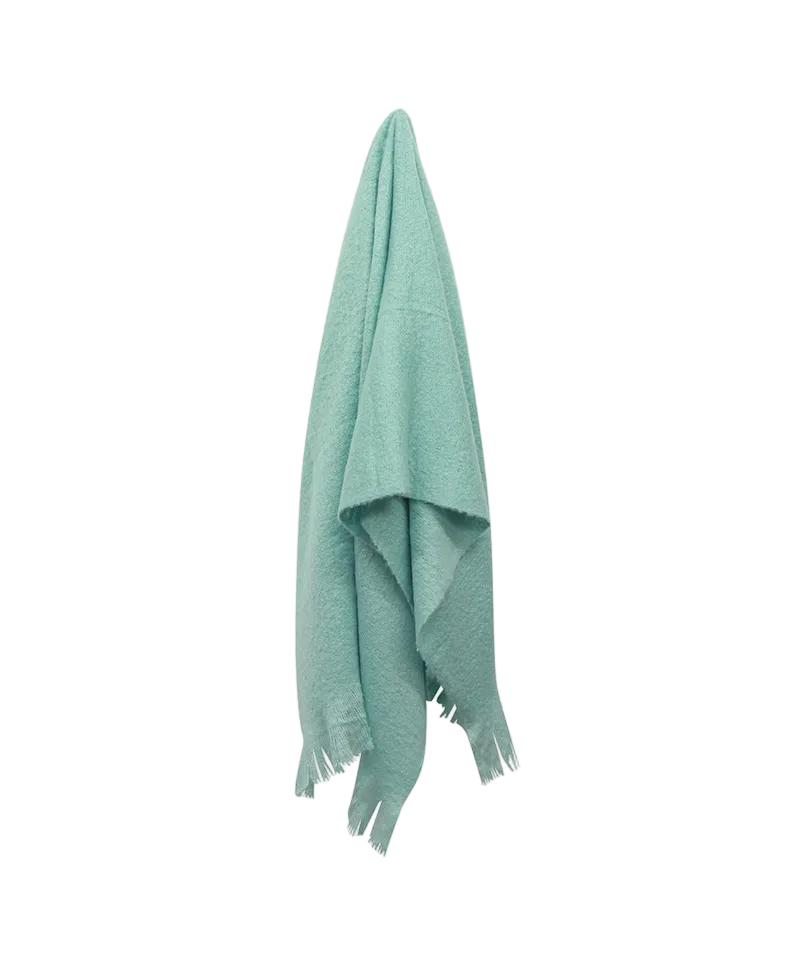 Green blanket with fringes on a white background