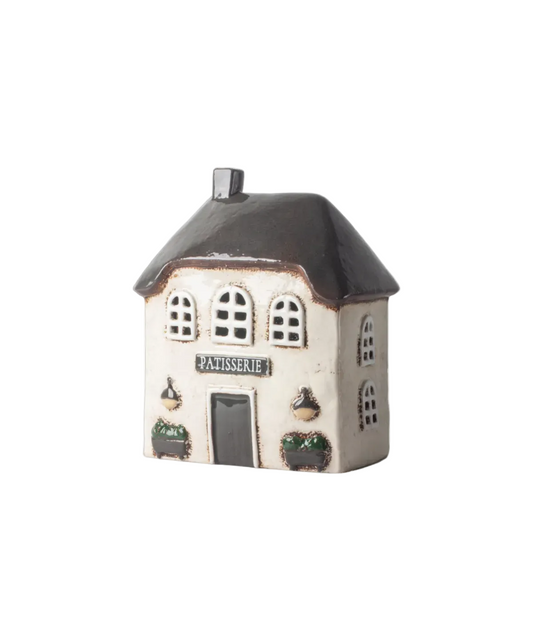 Small ceramic house model with 'Patisserie' sign on a white background